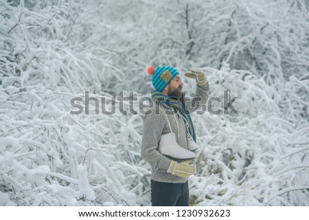 Bearded man with skates in snowy forest. skincare and beard care in winter. Temperature, freezing, cold snap, snowfall. Winter sport and rest, Christmas. Man in thermal jacket, beard warm in winter.