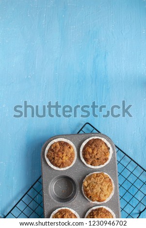 Homemade baking concept - fresh baked muffins on cooling rack, minimal picture, bright blue background, background, top view, copy space.