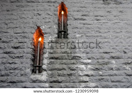 Burning candles on the stone wall in old castle