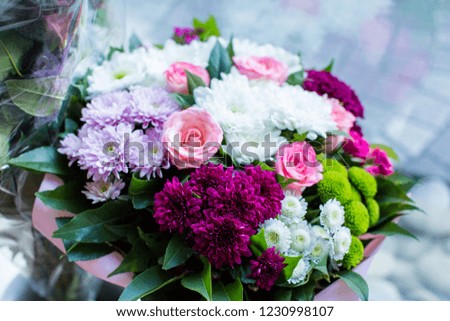 bunch of flowers with roses and chrysanthemum at the window