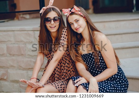 Beautiful girls dressed in retro dress. A preety ladies with a tape on her head. Famale in a summer city