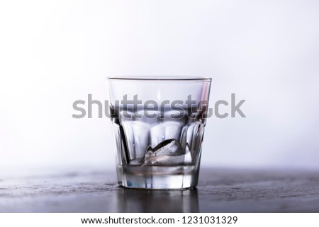 glass with ice isolated on table