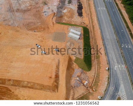 Aerial view of earthworks progress at the construction site by construction heavy machinery to get the required platform level. 