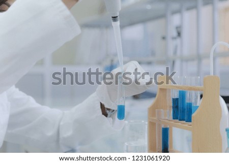 Young African Female Laboratory scientist working at lab with test tubes, test or research in clinical laboratory.Science, chemistry, biology, medicine and people concept.