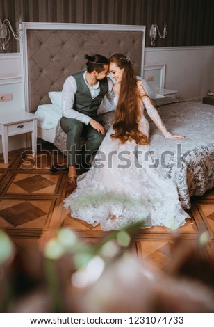 Beautiful couple sitting on bed in hotel room