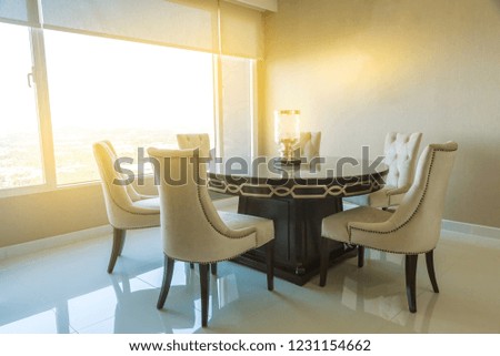 The dinning room decoration by beautiful set of chairs , table and light lamp on the table.