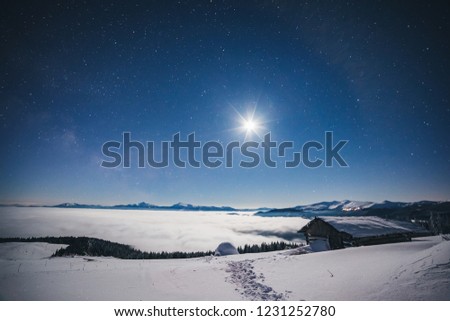 View at the starry sky over snowy hills. Dramatic and exotic scene. Location place Carpathian mountains, Ukraine, Europe. Astrophotography of milkyway. Winter wallpaper. Discover the beauty of earth.