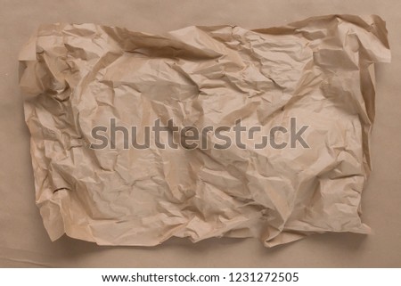 Brown crumpled Kraft paper lies on a flat surface. The view from the top, there is a place for copying.
