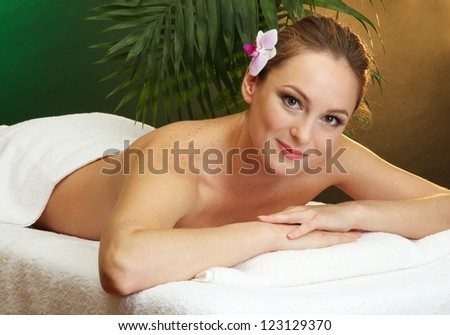 beautiful young woman in spa salon, on green background
