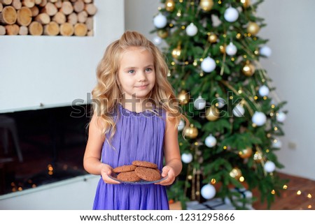 A little girl with blond hair prepared treats for Sanda. Christmas background, new year concept.