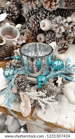 Christmas New Year candle glass decoration from pine cones, branches, blue sparkle shining balls, wooden stars, branches, decorative fruits in rustic, vintage style, background for greeting post card
