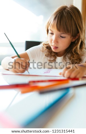 Careless little girl drawing with crayons at living room