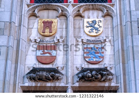 Various coat of arms on a historic building facade in Bruges, Belgium