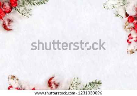 Christmas decoration. Frame of twigs christmas tree, red christmas balls, red berries and cones spruce in snow on snow with space for text. Top view, flat lay