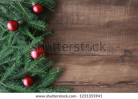 Fir tree branches and red baubles. Christmas background concept. Copy space on wooden boards.