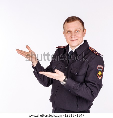 Russian policeman wearing original uniform  presenting and showing something on white background. law, emotion and people concept