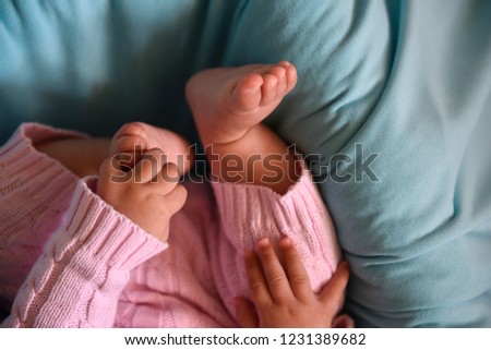 Close-up picture of baby holding her legs in her little armes