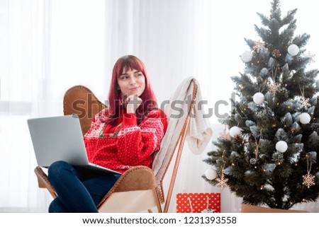 Young woman using laptop next to xmas tree, Christmas shopping online