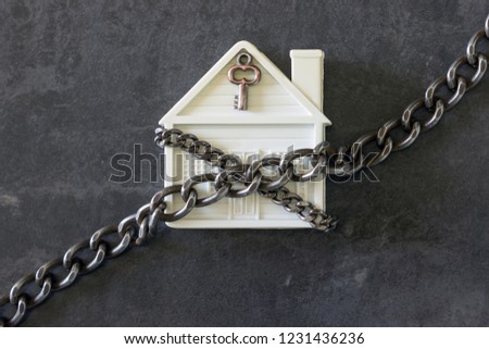  House in chains. Concept  -  risks, lose property,  seize, mortgage.  Royalty-Free Stock Photo #1231436236