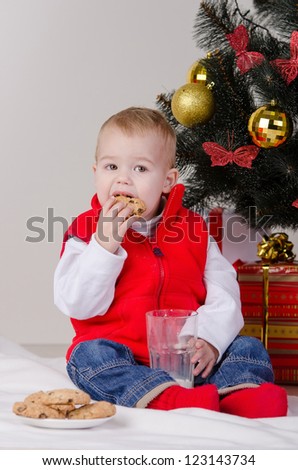 Little boy with milk and cookies for Santa Claus