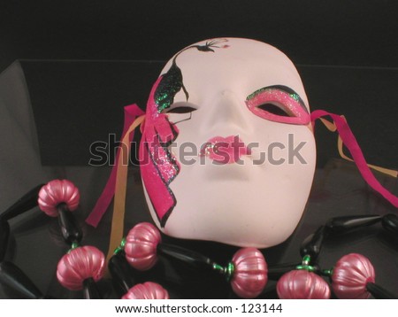 Mardi Gras mask and beads  with black background.