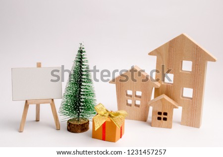 Wooden houses, Christmas tree and gifts. Christmas sale of real estate. New Year discounts for buying house. Purchase apartments at a low price. Winter resort and vacation. Copy space. space for text