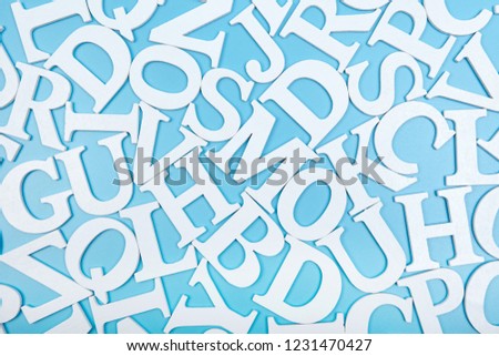  White wooden alphabet letters top view on blue background.