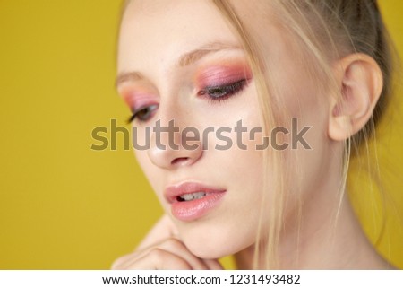 young girl with candy on a yellow bright background. beautiful make-up,