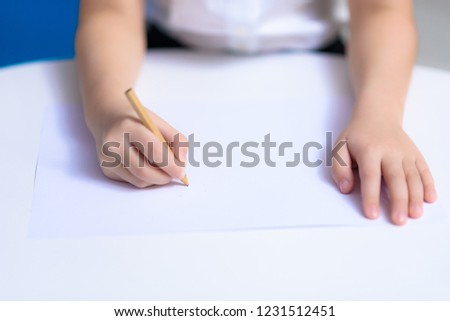 The concept of the child s hands is painted on the table on a sheet of white paper.