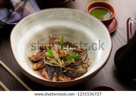 Asian food: fish with sprouts and peanuts in a restaurant side view