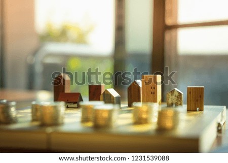 Wood house model and row of coin money on wood table, Real Estate market, Trading Estate, Mortgage Concepts