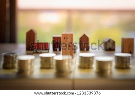 Wood house model and row of coin money on wood table with light blue background, Real Estate market, Trading Estate, Mortgage Concepts