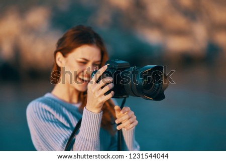smiling woman photographer with a camera in hand                    