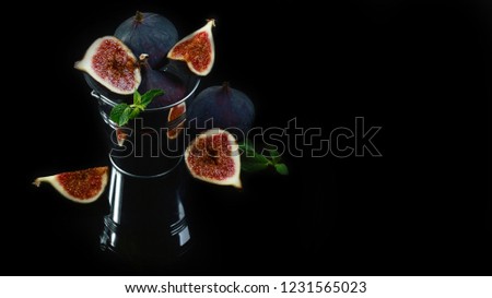 Ripe delicious figs in a bucket on black background. top view copy space