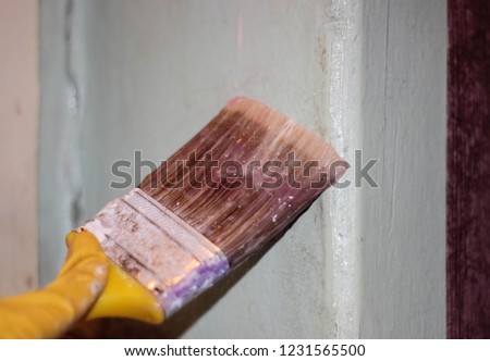 A dirty paint brush to apply Wallpaper glue on the wall. Repair. Brush the wall.