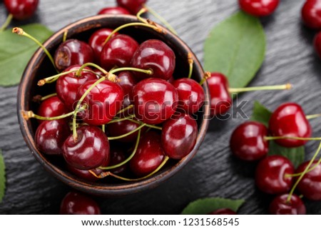 Red sweet cherries in a plate on a black background. space for text
