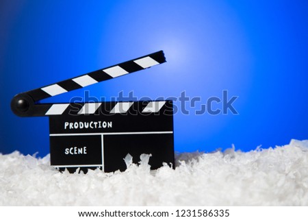 Frozen film clapper / clapperboard with copy space on blue background.