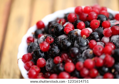 Frozen mixed berries as background. Currant mulberry texture pattern. Diet vegetarian food in winter.