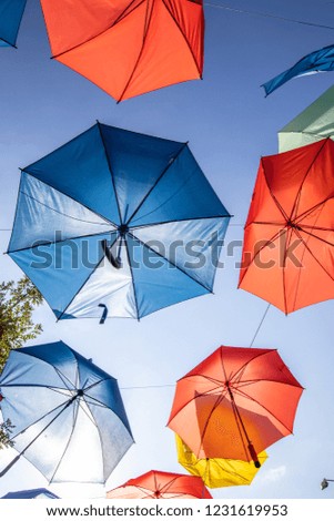 Colored umbrellas on the blue sky background on the street