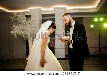 
Wedding moment cutting cake. Magnificent brides feed each other out of a spoon