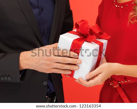 closeup picture of man and woman's hands with gift box