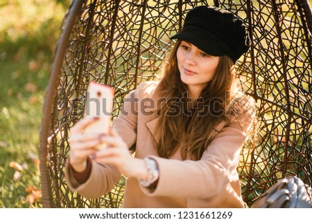 young beautiful girl in a coat and hat with phone