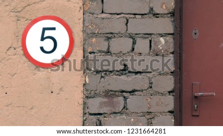 number five in a white and red circle on a brick wall background, speed limit sign
