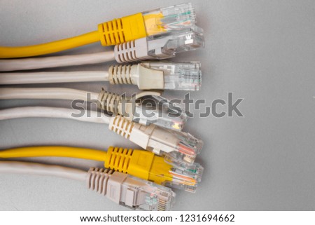 Close up of white and yellow network cables, selective focus, on gray background, shallow depth of field