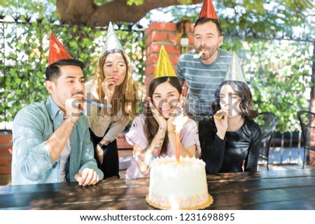 Delighted woman enjoying surprise birthday party by multiethnic friends at burger shop