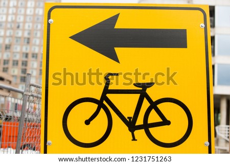Yellow sign with black bicycle and arrow