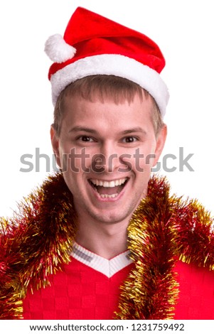 Thinking for christmas gift ideas. Funny smiling guy with a Santa hat and tinsel around the neck. Portrait