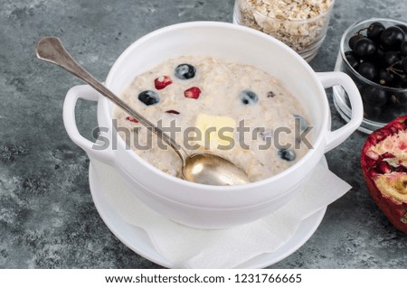 Oatmeal with butter and berries. Studio Photo