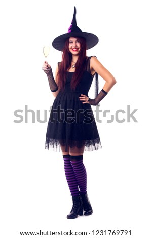 Photo of smiling witch with wine glass with wine in black dress and hat