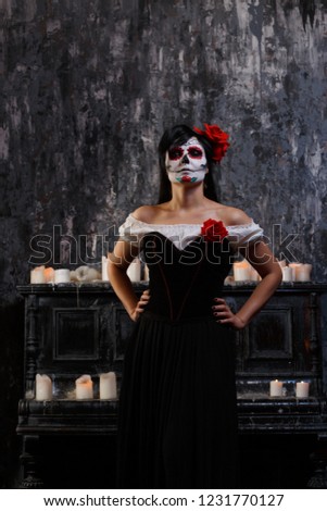 Portrait of zombie woman with white face and red flower on her head